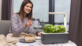 Woman growing lemon balm in the Smart Garden 3 during winter.